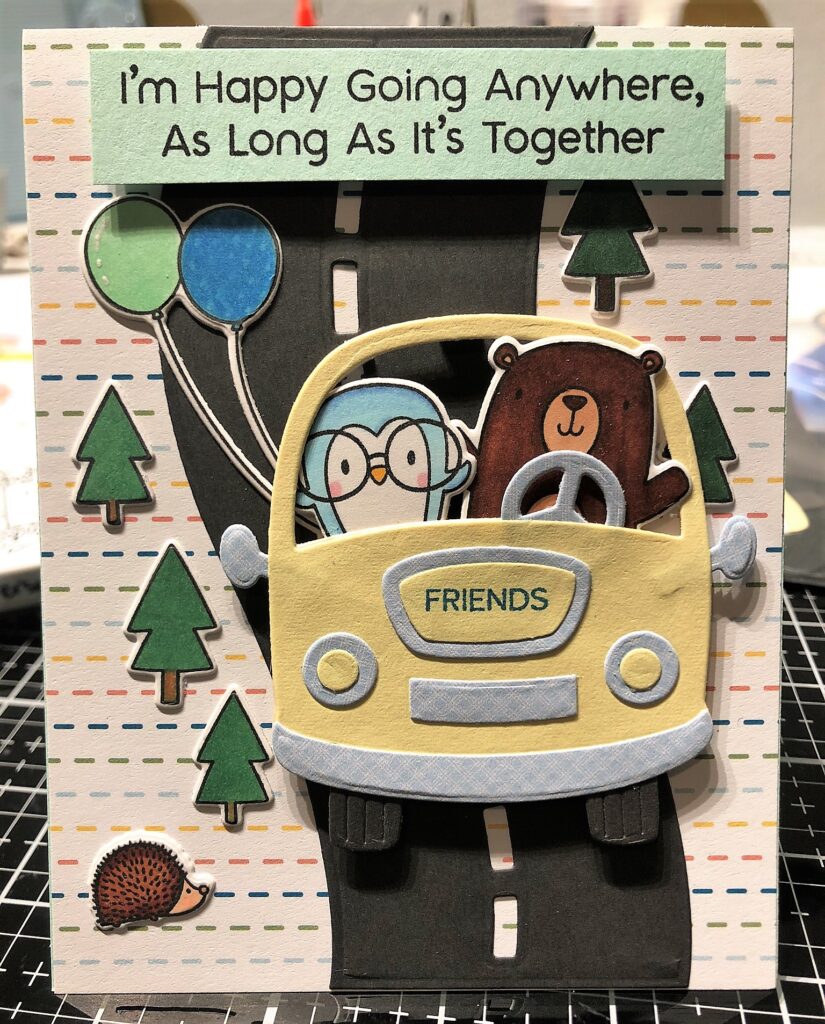 Card with cartoon penguin and bear in a yellow car on a tree-lined black road with the saying "I'm Happy Going Anywhere, As Long As It's Together" 