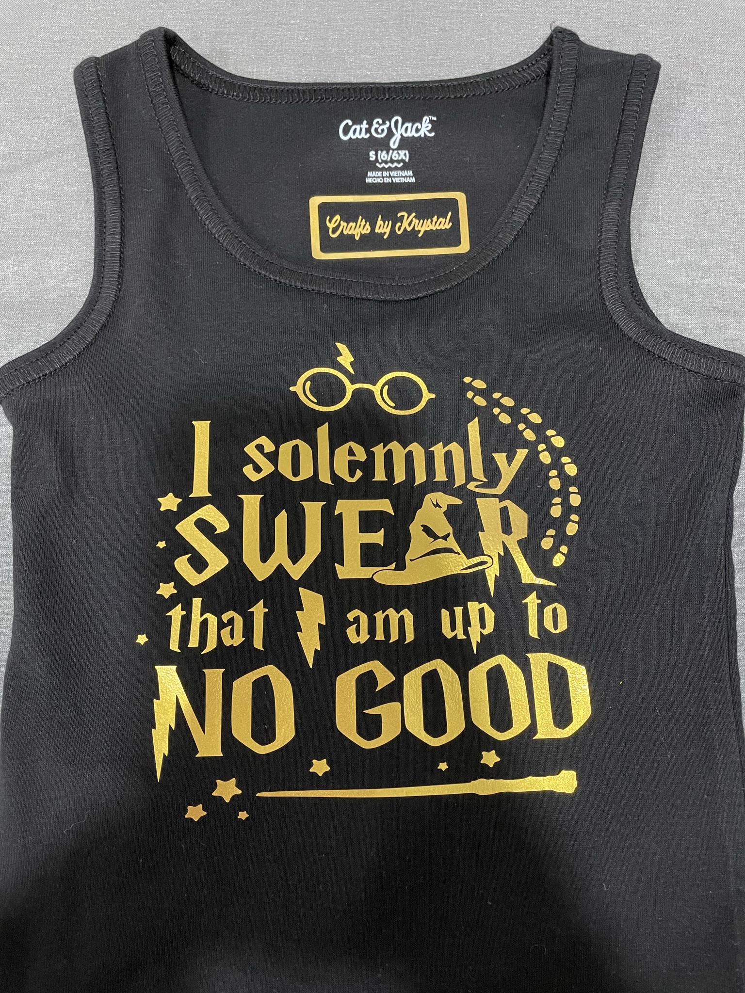 Black tank top with gold design that says "I solemnly swear that I am up to no good" in Harry Potter style